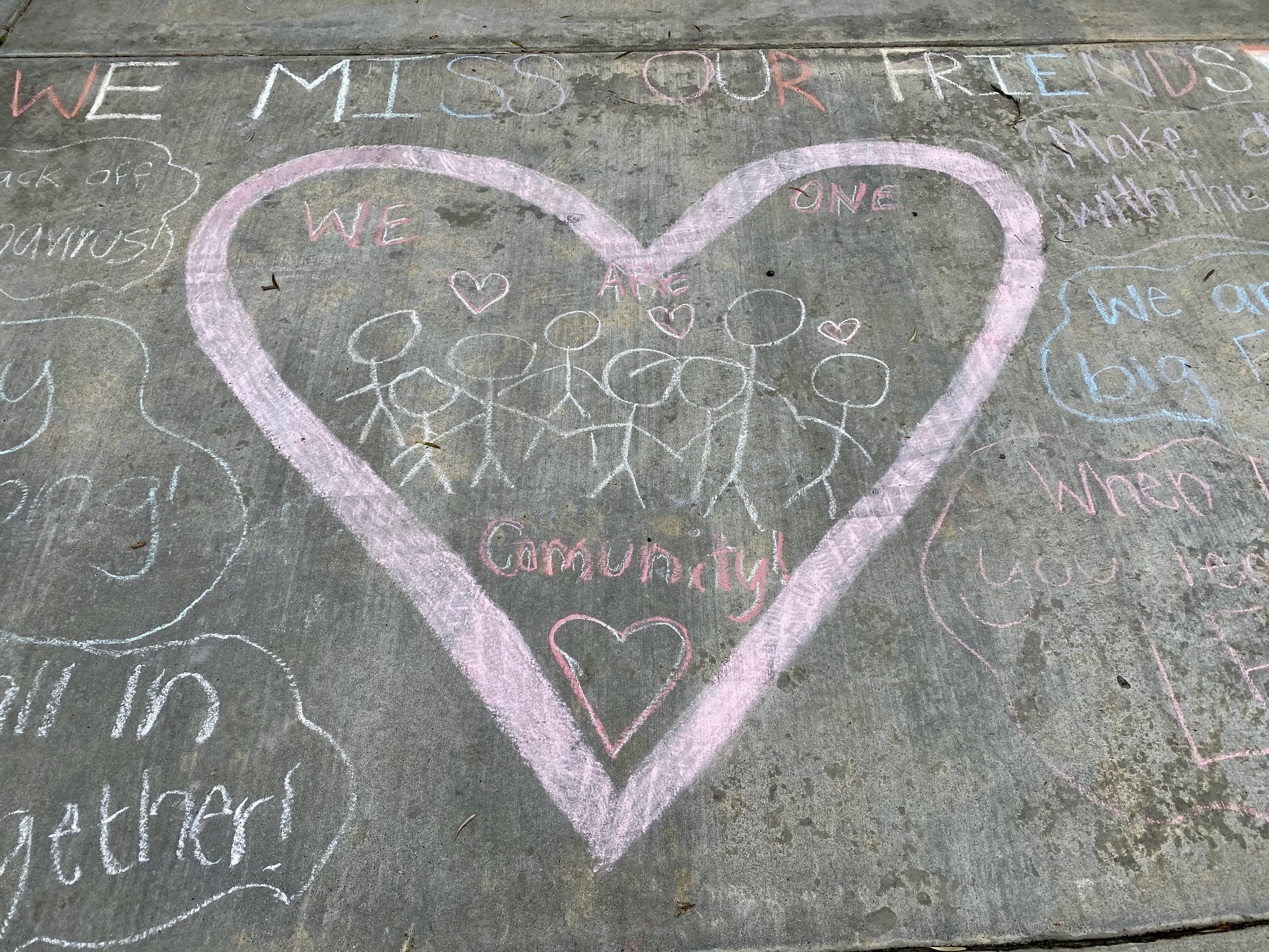 Children have drawn a heart in chalk during the pandemic and they say they miss their friends