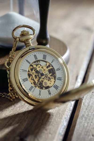 Gold pocket watch and hourglass