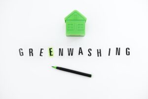 Greenwashing concept with green and black pen and plastic house. Greenwashing marketing ploy