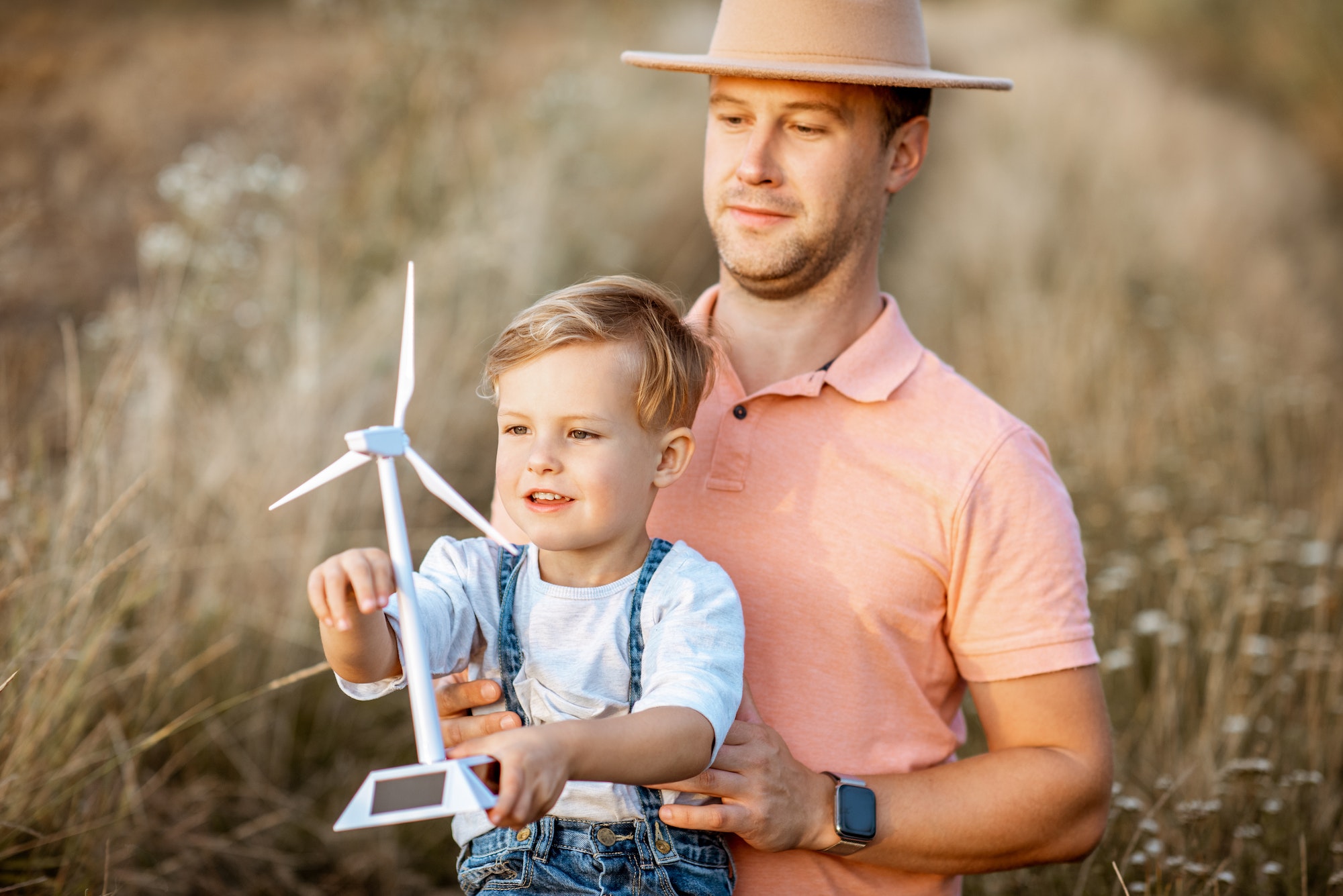 Father and young son playing with wind turbine