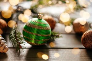 Merry Christmas greeting card with green Christmas ball and Christmas light bokeh