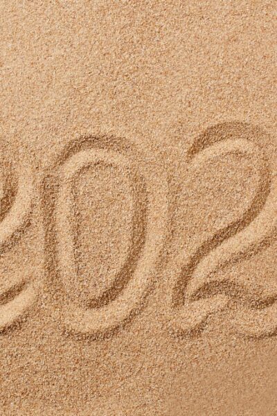 Happy New Year 2024 greeting card. The numbers 2024 on the sand on the beach